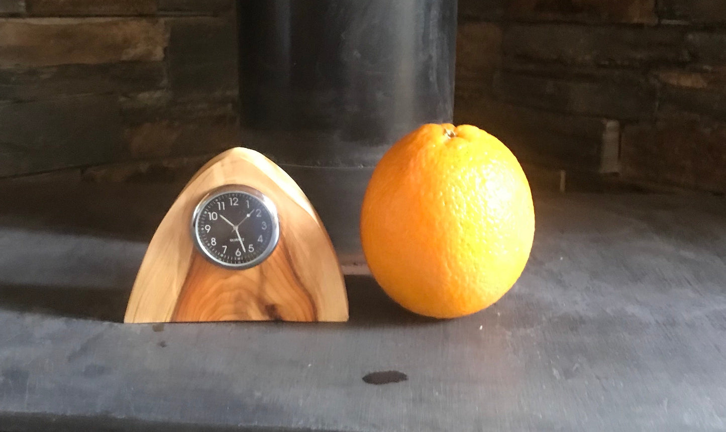 Handmade miniature clock in yew in unique design. There is a choice of two different clock face colours